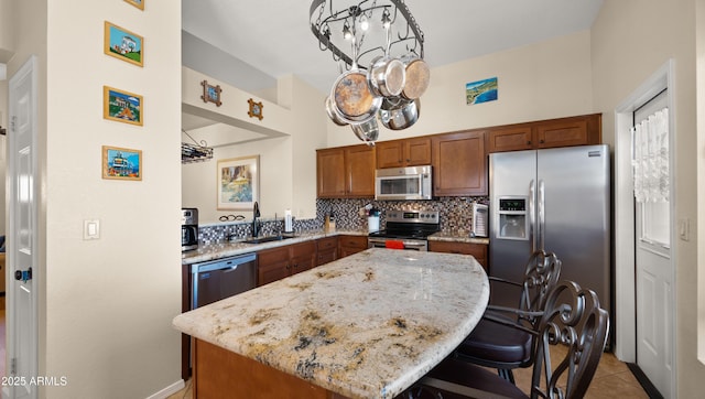 1910 E Citation Ln, Tempe, AZ 85284 - kitchen with appliances with stainless steel finishes, a sink, light stone counters, a kitchen breakfast bar, and a center island
