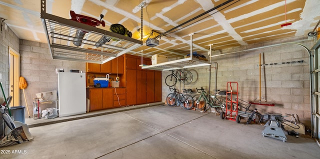 1910 E Citation Ln, Tempe, AZ 85284 - garage featuring freestanding refrigerator, concrete block wall, and a garage door opener
