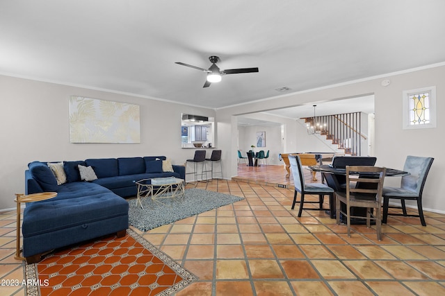 living room with tile patterned floors, ceiling fan with notable chandelier, and ornamental molding