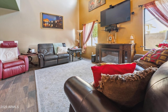 living room with a high ceiling and wood finished floors