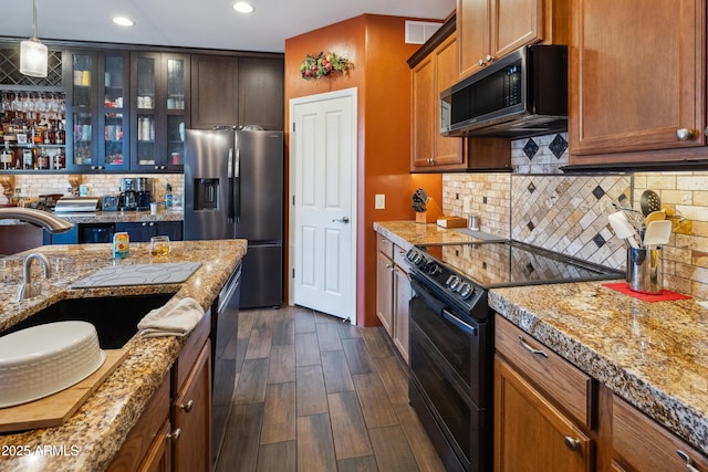 kitchen with visible vents, a sink, stainless steel appliances, glass insert cabinets, and backsplash