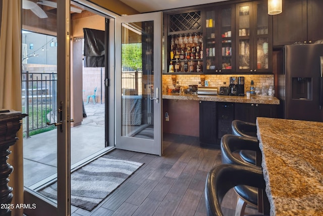 interior space featuring a dry bar, french doors, and dark wood-style flooring