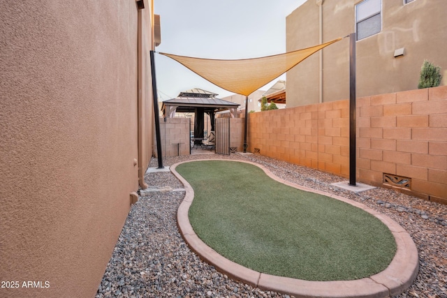 view of yard featuring a gazebo and a fenced backyard