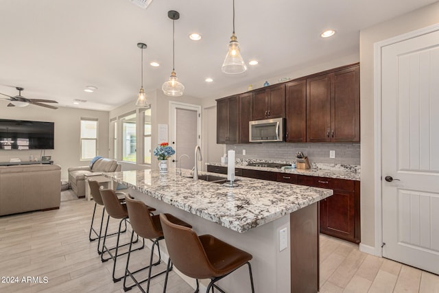 kitchen with light hardwood / wood-style flooring, ceiling fan, stainless steel appliances, and pendant lighting