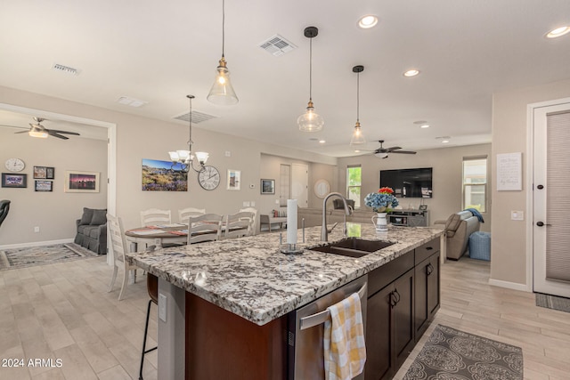 kitchen featuring ceiling fan with notable chandelier, dishwasher, hanging light fixtures, sink, and light wood-type flooring