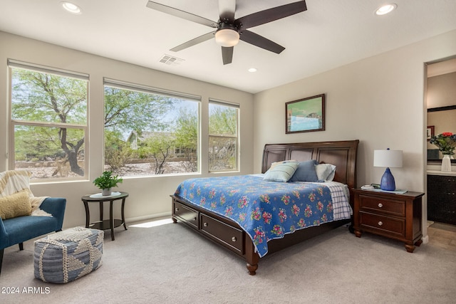 carpeted bedroom with multiple windows and ceiling fan