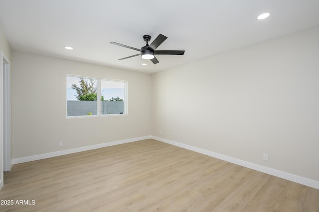 spare room featuring baseboards and light wood-type flooring