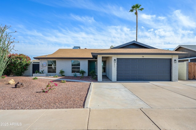 ranch-style home featuring concrete driveway, brick siding, fence, and a garage