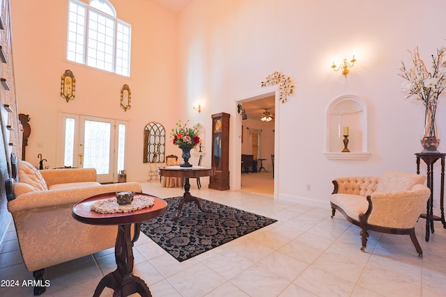 tiled living room featuring ceiling fan and a towering ceiling