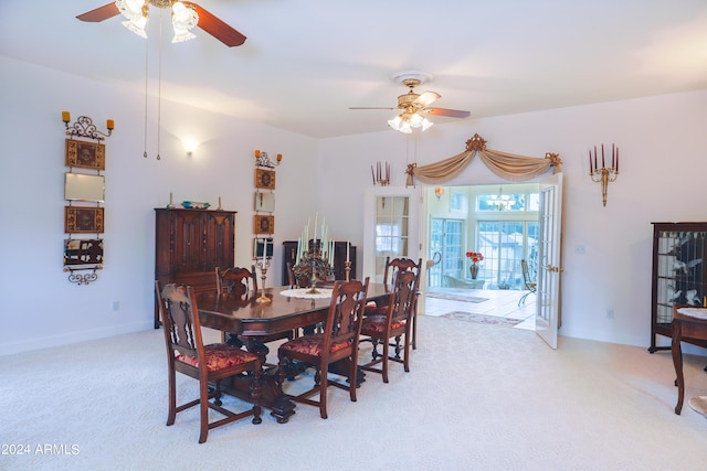 dining room with ceiling fan, light colored carpet, and french doors