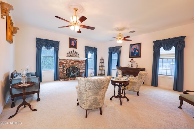 carpeted living room featuring a brick fireplace, ceiling fan, and a healthy amount of sunlight