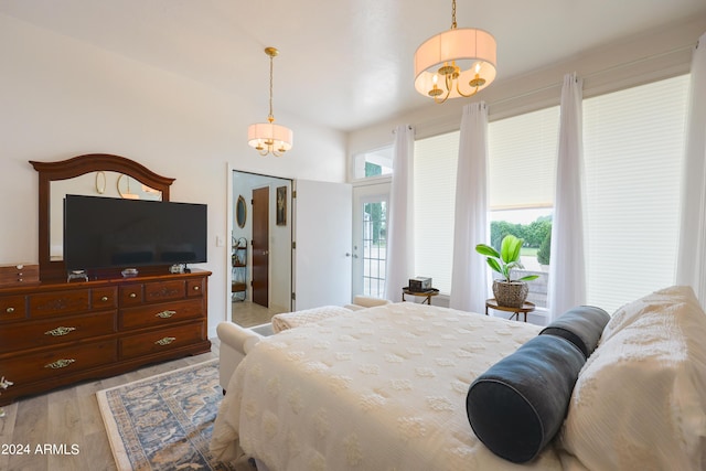 bedroom with a notable chandelier and light hardwood / wood-style flooring