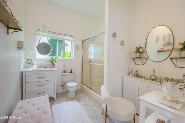 bathroom with vanity, a shower with shower door, and toilet