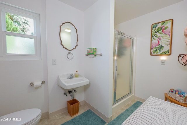 bathroom with a shower with door, tile patterned floors, and toilet