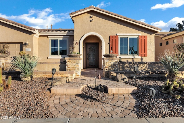 view of front of home featuring a tiled roof and stucco siding