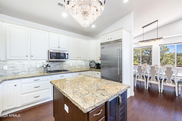 kitchen featuring a notable chandelier, lofted ceiling, visible vents, appliances with stainless steel finishes, and dark wood-type flooring