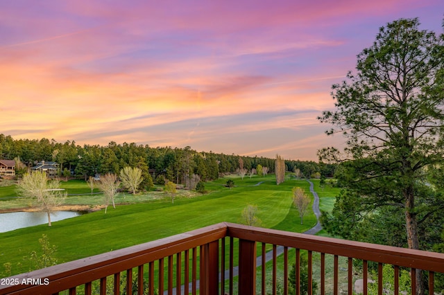 deck with a water view and a lawn