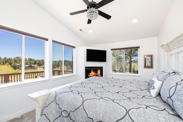 carpeted bedroom with lofted ceiling, recessed lighting, a ceiling fan, baseboards, and a lit fireplace