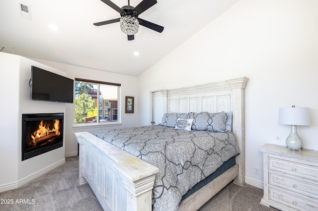 bedroom with a warm lit fireplace, visible vents, vaulted ceiling, and carpet flooring