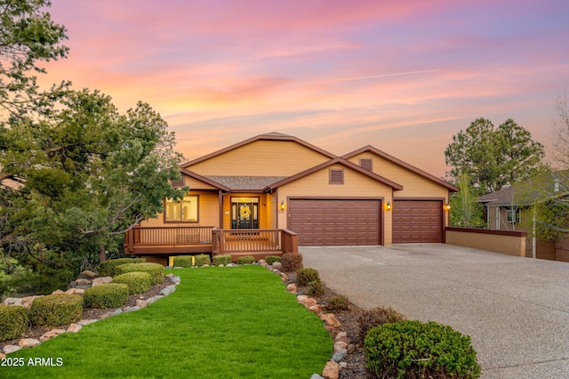 view of front of home with a garage, a lawn, and aphalt driveway