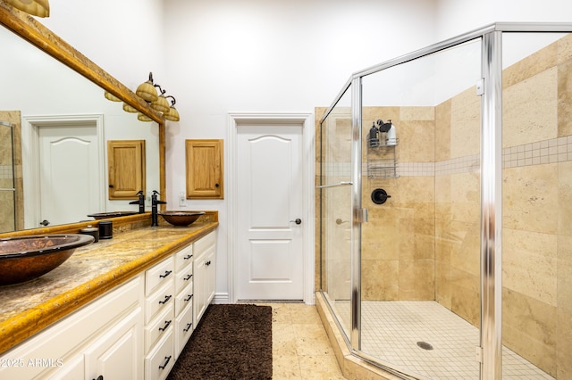 full bath with double vanity, tile patterned floors, a sink, and a shower stall