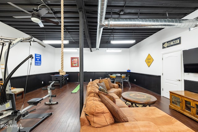 interior space with ceiling fan, wainscoting, and wood finished floors