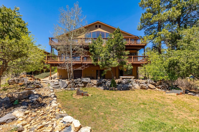 rear view of property featuring a lawn and a deck