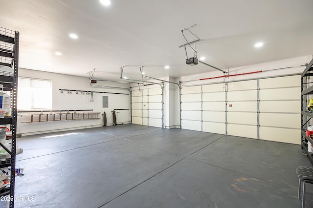 garage with recessed lighting, electric panel, and a garage door opener