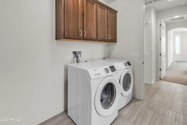 4279 N Spyglass Dr, Florence, AZ 85132 - washroom with cabinet space, washing machine and clothes dryer, visible vents, baseboards, and arched walkways