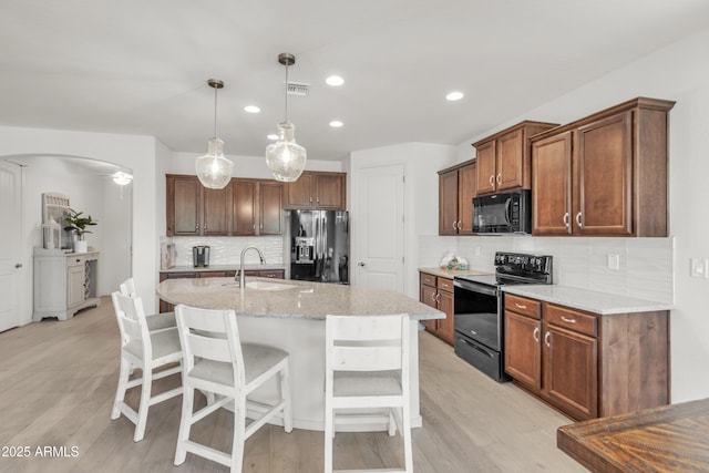 4279 N Spyglass Dr, Florence, AZ 85132 - kitchen with range with electric stovetop, backsplash, fridge with ice dispenser, light wood finished floors, and black microwave