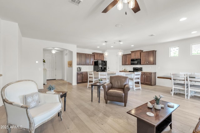 4279 N Spyglass Dr, Florence, AZ 85132 - living room featuring recessed lighting, light wood-style floors, a ceiling fan, visible vents, and arched walkways