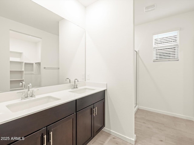 bathroom with vanity, hardwood / wood-style flooring, and a shower with shower door