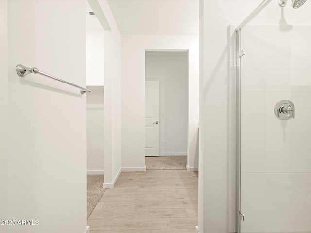 bathroom with hardwood / wood-style flooring and a shower with door