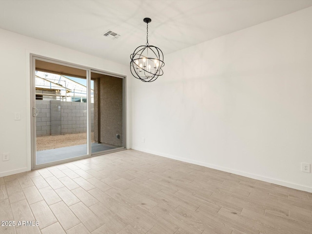 unfurnished room featuring an inviting chandelier and light hardwood / wood-style flooring