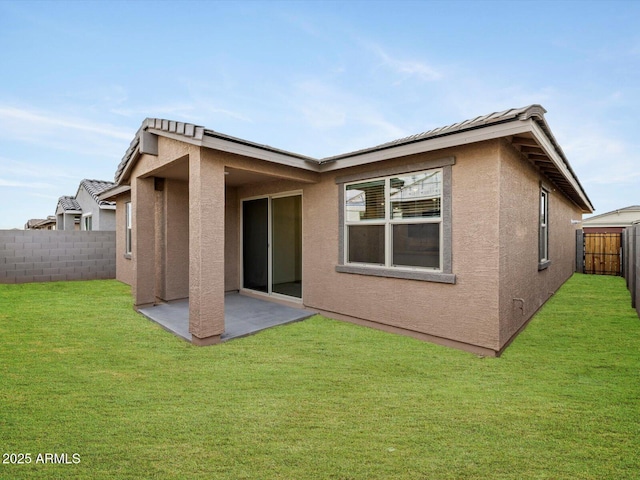 rear view of house with a lawn and a patio area