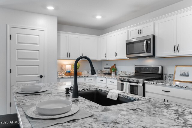 654 E Buckingham Ave, Gilbert, AZ 85297 - kitchen with appliances with stainless steel finishes, white cabinets, light stone counters, and recessed lighting