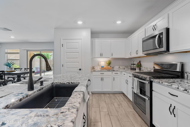 654 E Buckingham Ave, Gilbert, AZ 85297 - kitchen featuring appliances with stainless steel finishes, white cabinets, light stone countertops, and recessed lighting