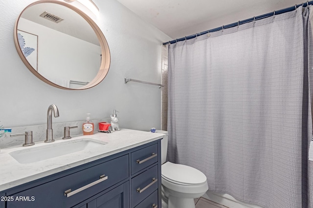 bathroom featuring a shower with shower curtain, vanity, and toilet