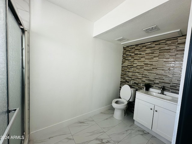 bathroom featuring a textured ceiling, vanity, tasteful backsplash, and toilet