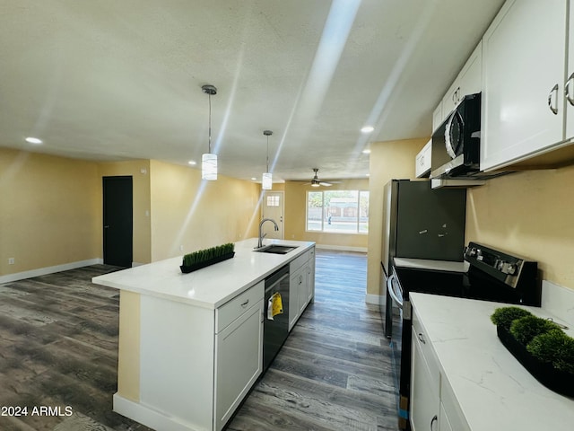 kitchen with pendant lighting, white cabinets, sink, an island with sink, and appliances with stainless steel finishes