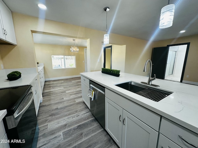 kitchen with hanging light fixtures, light wood-type flooring, sink, and appliances with stainless steel finishes