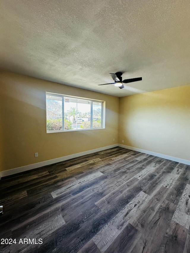 spare room featuring a textured ceiling, ceiling fan, and dark wood-type flooring