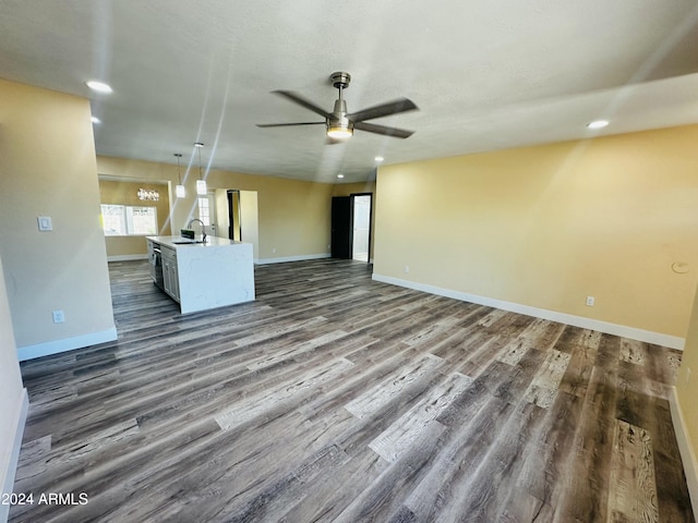 unfurnished living room with dark hardwood / wood-style floors, ceiling fan, and sink