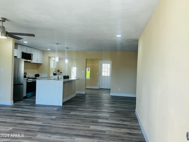 kitchen featuring pendant lighting, ceiling fan, appliances with stainless steel finishes, dark hardwood / wood-style flooring, and white cabinetry