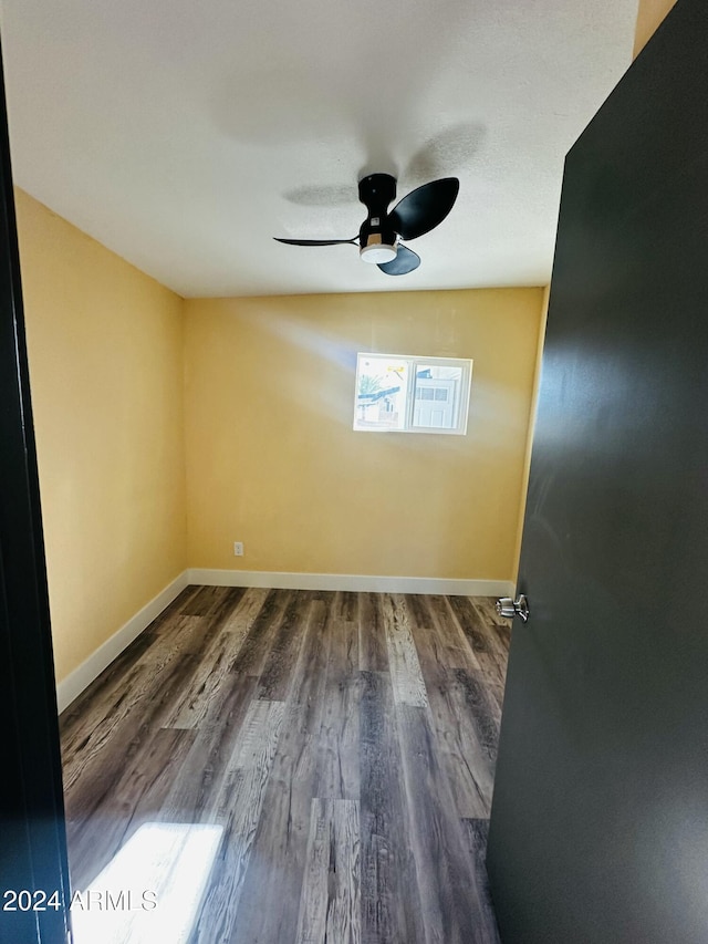 empty room with ceiling fan and dark hardwood / wood-style flooring