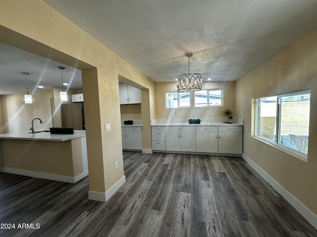 kitchen with white cabinets, decorative light fixtures, dark hardwood / wood-style flooring, and a chandelier