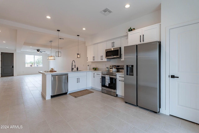 kitchen featuring kitchen peninsula, hanging light fixtures, white cabinetry, sink, and stainless steel appliances