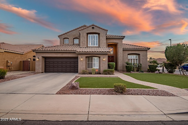 mediterranean / spanish-style house featuring a yard and a garage