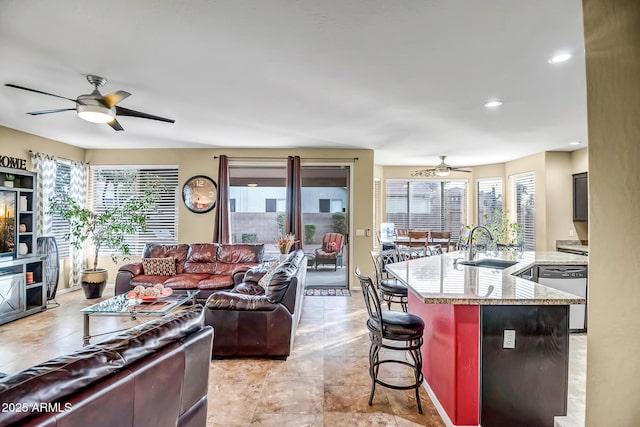 living room featuring sink, ceiling fan, and plenty of natural light