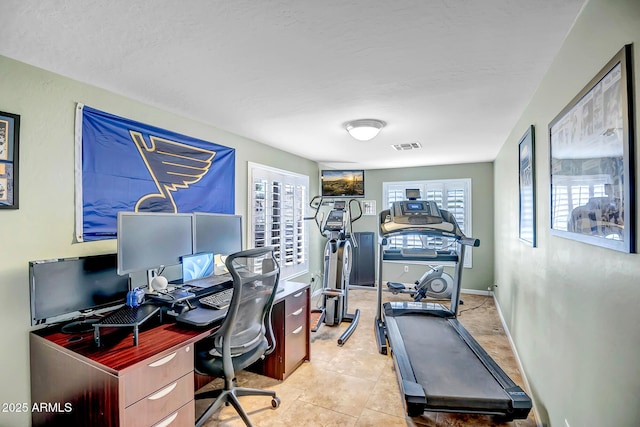 tiled home office with a textured ceiling